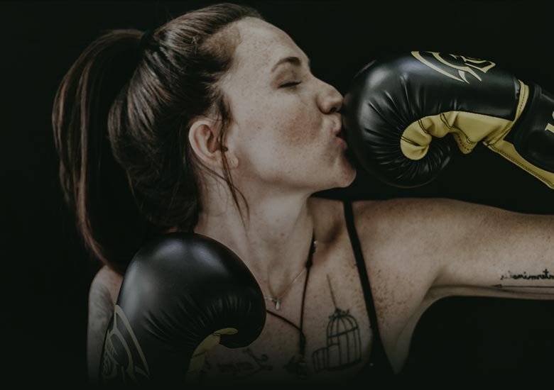 A woman kissing her boxing gloved-hand