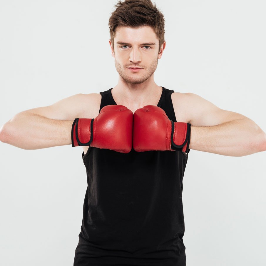 A man staring at the camera, wearing a custom boxing vest