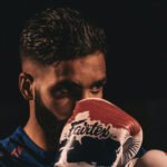 A man staring pensively behind his boxing gloves