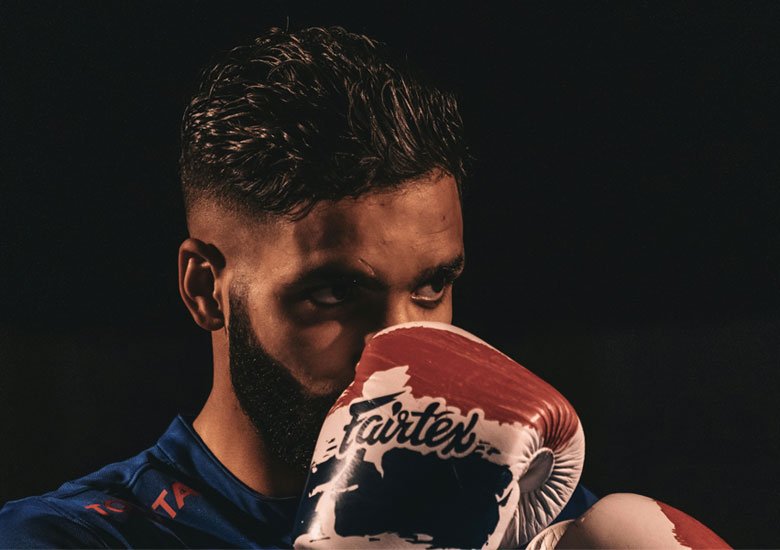 A man staring pensively behind his boxing gloves